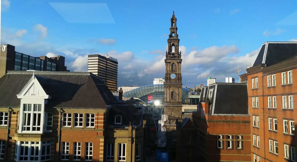 City centre office blocks with church spire and glazed dome shopping centre roof