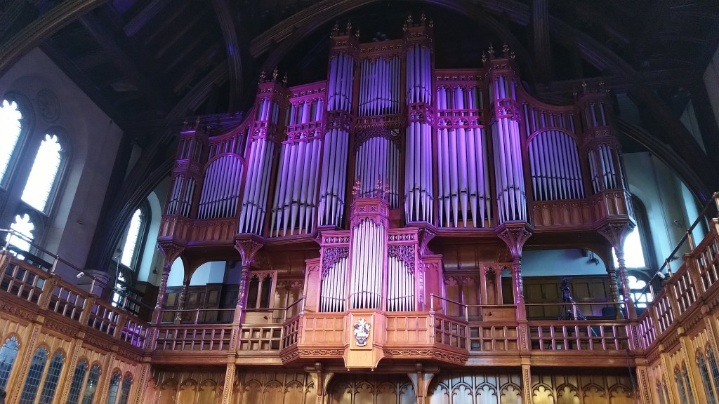 Large pipe organ above a balcony in a gothic hall